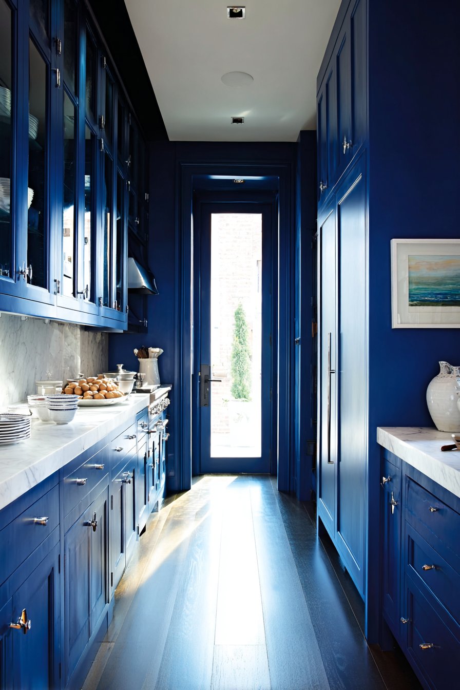 Space-Maximizing Galley Kitchen with Floor-to-Ceiling Navy Blue Cabinets